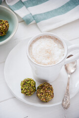 A cup of coffee and pistachio candies