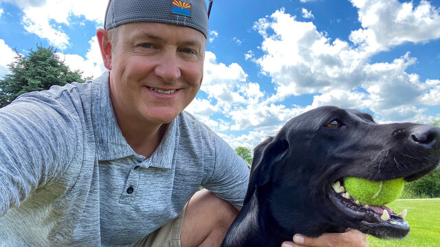 man and dog playing fetch blue country sky - Powered by Adobe