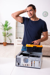 Young man repairing computer at home