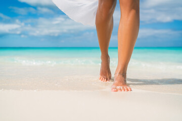 Elegant woman on luxury Caribbean beach vacation relaxing in summer tropical ocean background....