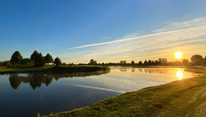 morning sun over golf course pond