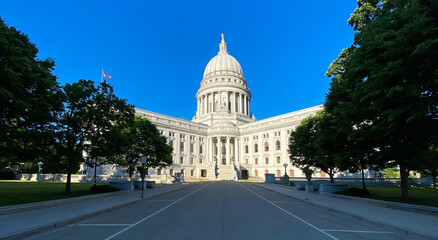 state capitol building with flags bright blue skies
