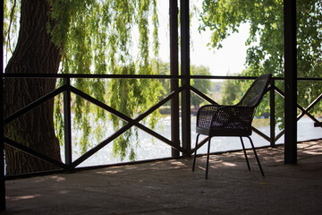 Wooden terrace with wicker chair overlooking the lake