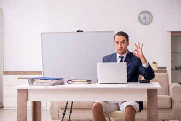 Young male employee working at home during pandemic disease