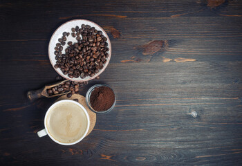 Vintage coffee background with space for text. Coffee cup, coffee beans and ground powder. Flat lay.