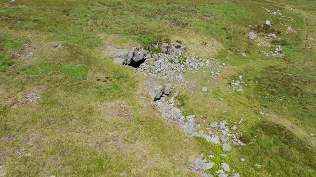 Low altitude drone view of the entrance to the historic and remote Chartist Cave on Llangynidr Moors in South Wales, UK