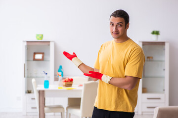 Young male contractor cleaning the house