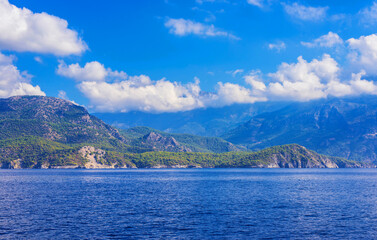 Forest covered mountains descend to the surface of the sea.