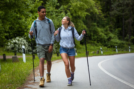 Young Mixed Race Couple Hiking In Nature.They Walking By The Old Country Road.	
