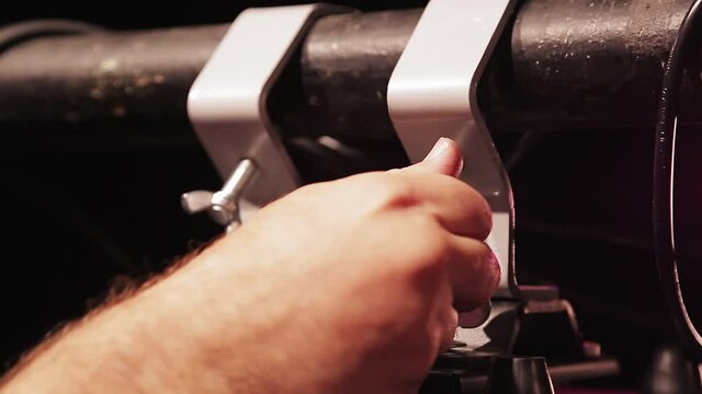 A male hand secures a screw on a soffit hanging on a shank