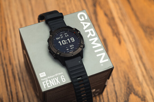 Garmin Fenix 6 Pro smart watch on box on wooden background. Unpacking purchase concept