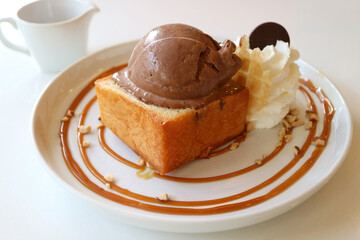 Honey butter maple syrup toast topped with chocolate ice cream served on white table