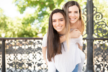 Fototapeta premium Happy Woman Piggybacking Friend and having fun