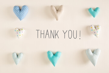 Thank You message with blue heart cushions on a white paper background