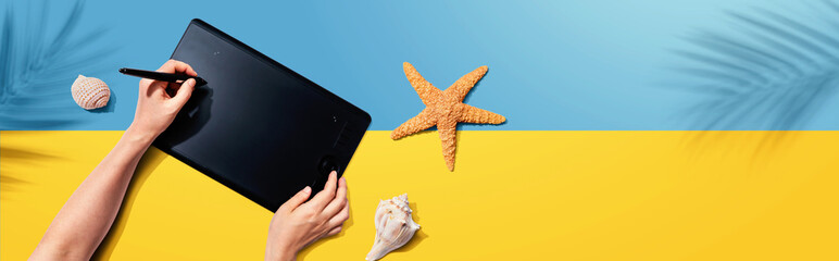 Graphic pen tablet with starfish and sea shells - flat lay