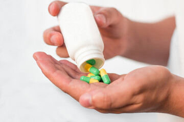 Pouring capsules from a pill bottle into hand