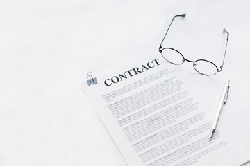 Signing contract with glasses nearby