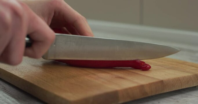 Female hands chop and slice Ramiro pepper into pieces with knife