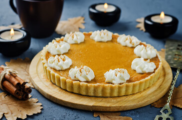 Pumpkin pie with whipped cream and cup of tea