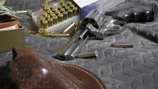 60p/Slomotion: Slow tilt up with focus pull from a leather bound holster to the barrel of a Handgun; a .357 Revolver.