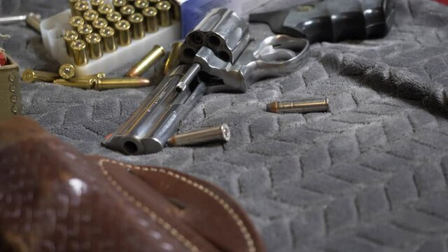 60p/Slomotion: Slow tilt up with focus rack from a Leather Holster to a Shiny new Handgun; a .357 Revolver.