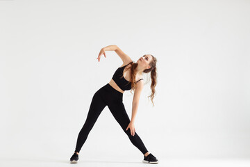 Beautiful fitness model practices yoga or pilates, standing in Triangle yoga pose, Trikonasana,...