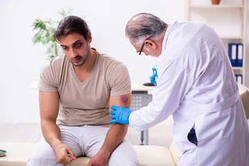 Young face injured man visiting experienced male doctor traumato