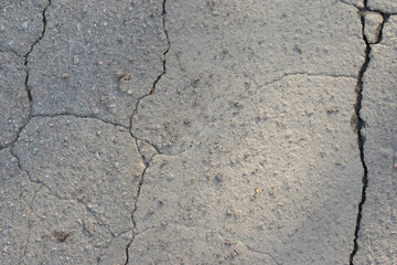 Old asphalt with cracks, gray background