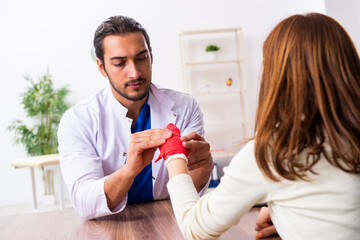 Young hand injured woman visiting male doctor traumatologist