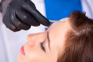 Fototapeta premium Young woman visiting male beautician in hair transplantation con