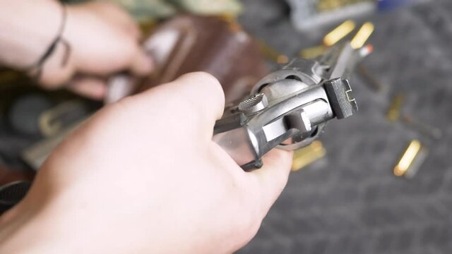 60p/Slomotion: Drawing a .357 revolver from leather holster to check if it had bullets in it or not.