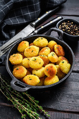 Homemade Potato Gnocchi fried in a pan.  Black wooden background. Top view.