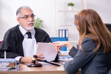 Old male judge and female client in the office