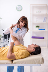 Injured man visiting young female doctor osteopath