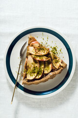 italian apple pie crostata with pistachio crumbs on the table with a white tablecloth