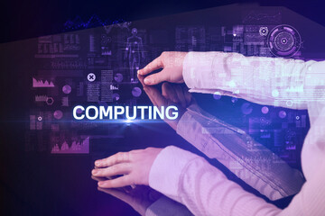 Businessman touching huge display with COMPUTING inscription, modern technology concept