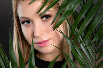 Woman's blue green eye with pupil heterochromia with beautiful make-up and thick eyebrows. Looking...