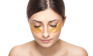 Collagen gold patches under the eyes against wrinkles and dry skin on the face of a beautiful woman. Female aesthetic cosmetology in a beauty salon.Cosmetology concept.