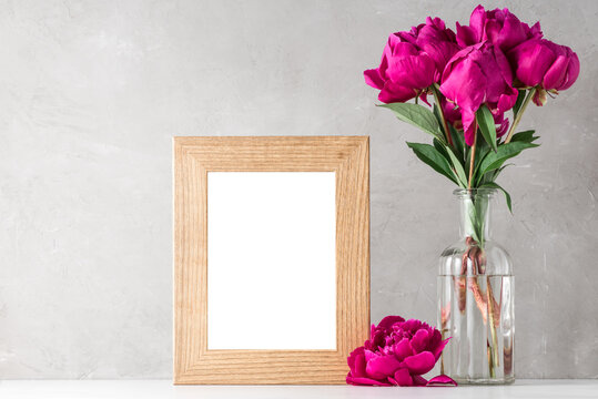 red peony flowers bouquet with blank photo frame on white background. mock up. still life. holiday concept