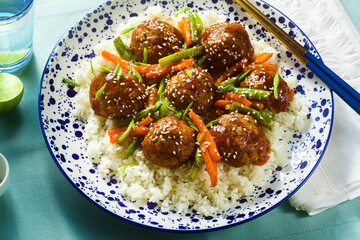 meatless vegan Asian meatballs in sweet and sour sauce with rice and stewed vegetables. balanced lunch or healthy dinner. street food