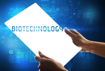 Hand holdig futuristic tablet with BIOTECHNOLOGY inscription, new technology concept