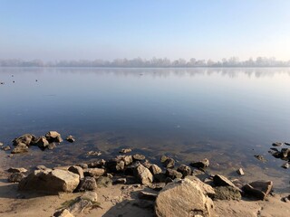 Calm and peaceful lake in the foggy morning
