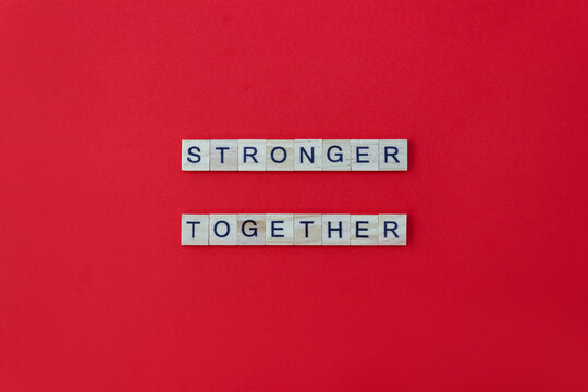 Words Stronger Together. Wooden Blocks With Lettering On Red Background. Minimal Concept. Top View, Layout