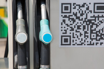 Petrol pump filling nozzles and QR code are on gas station. Concept contactless payment, safety - 362251544