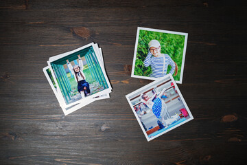 Fototapeta na wymiar Square photos from a family photo album on wood table background. Flat lay.