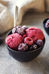 Delicious homemade summer berries yogurt ice cream with berries on grey background