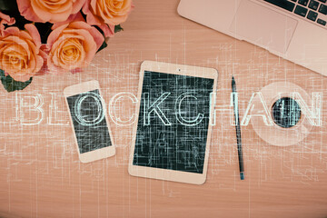 Double exposure of blockchain theme hologram over table with phone. Top view. Crypto technology...