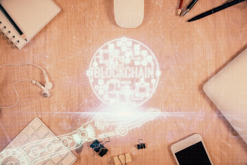 Double exposure of blockchain theme hologram over table with phone. Top view. Crypto technology...
