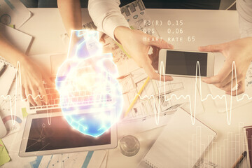 Double exposure of man and woman working together and heart hologram drawing. Computer background. Top View.