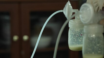 Mom use electric breast pump feeding for her baby.